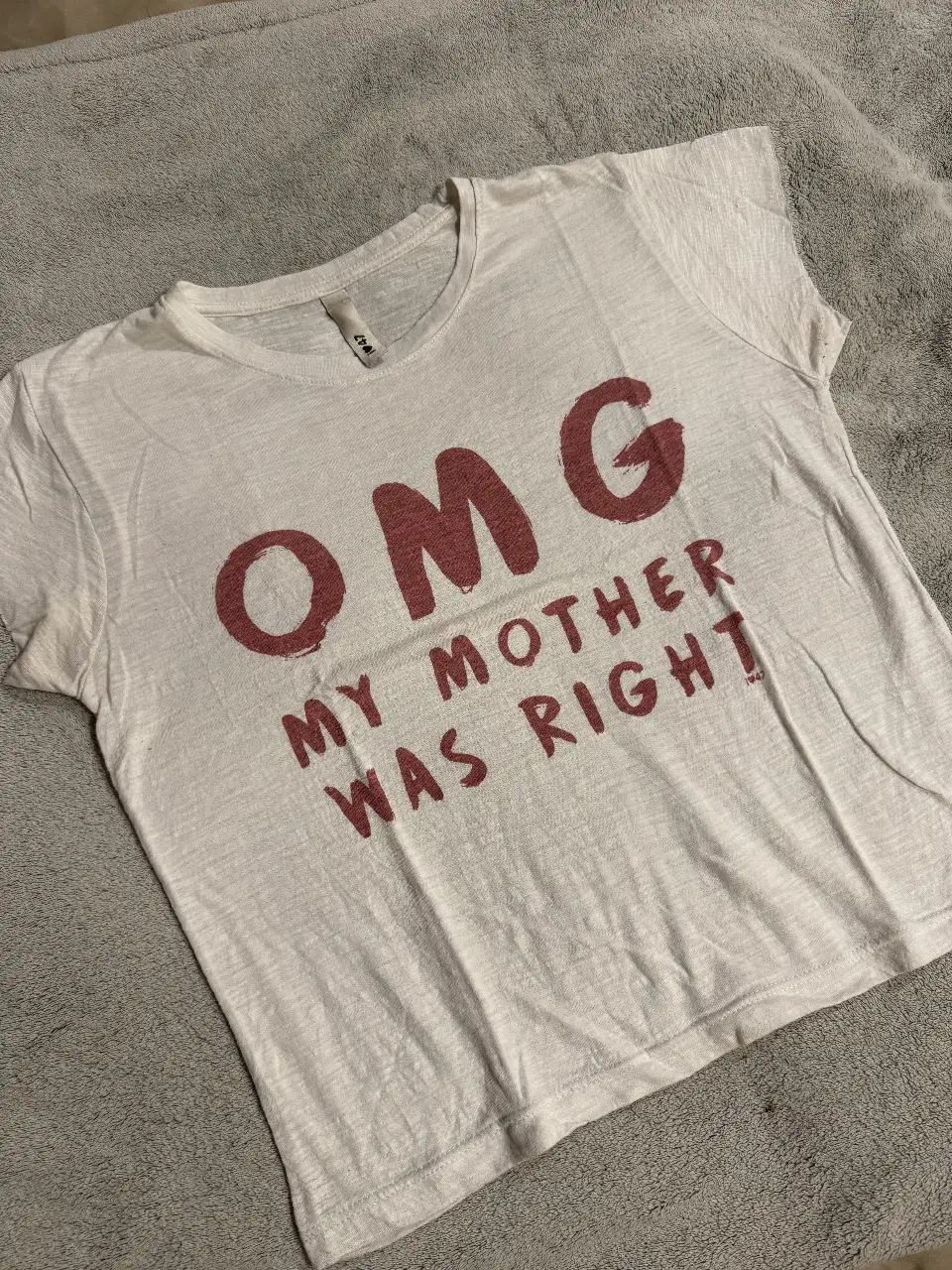 Remera blanca con estampado "OMG MY MOTHER WAS RIGHT" en color borravino. Ideal para un look casual y divertido. Perfecta para combinar con jeans o shorts.