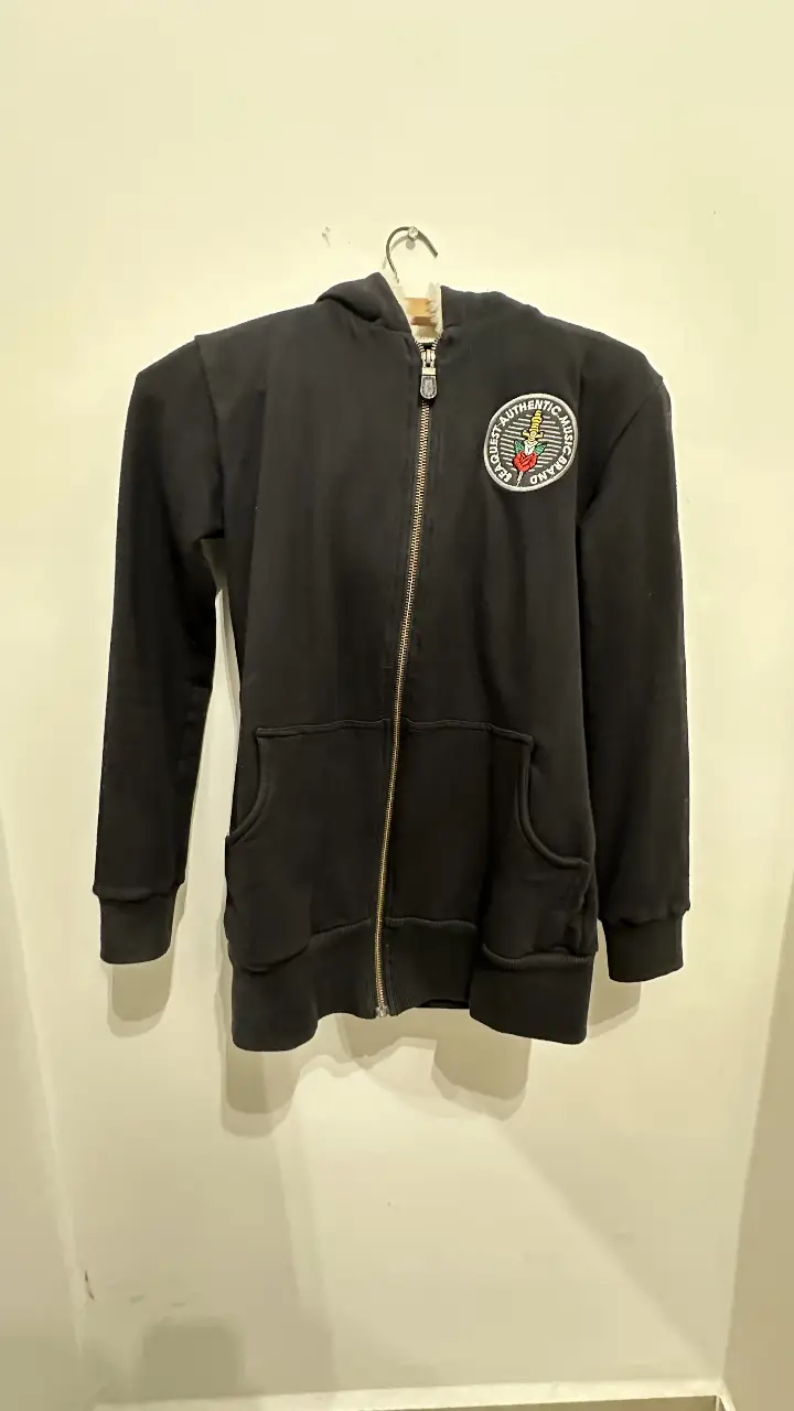campera con cierre negra de la marca Seaquest, con capucha y bolsillo tipo canguro. En la espalda, un diseño de daga y rosa. Ideal para un look casual y urbano.