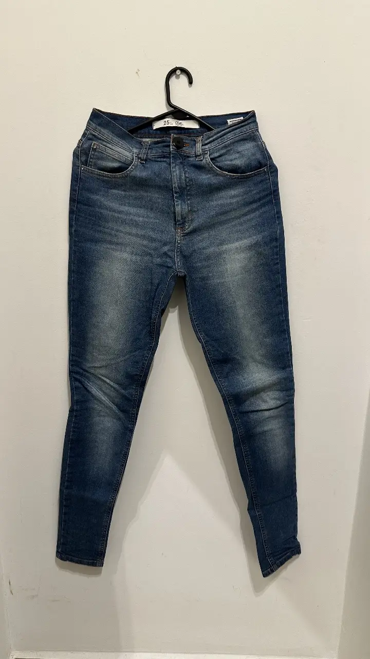 Jeans skinny color azul, con detalles de desgaste y botón negro. Talle 25/34.