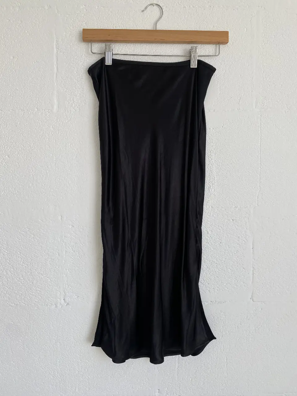 Pollera midi de satén negro H&M, ideal para un look elegante y sofisticado. Perfecta para combinar con diferentes tops y crear outfits versátiles.