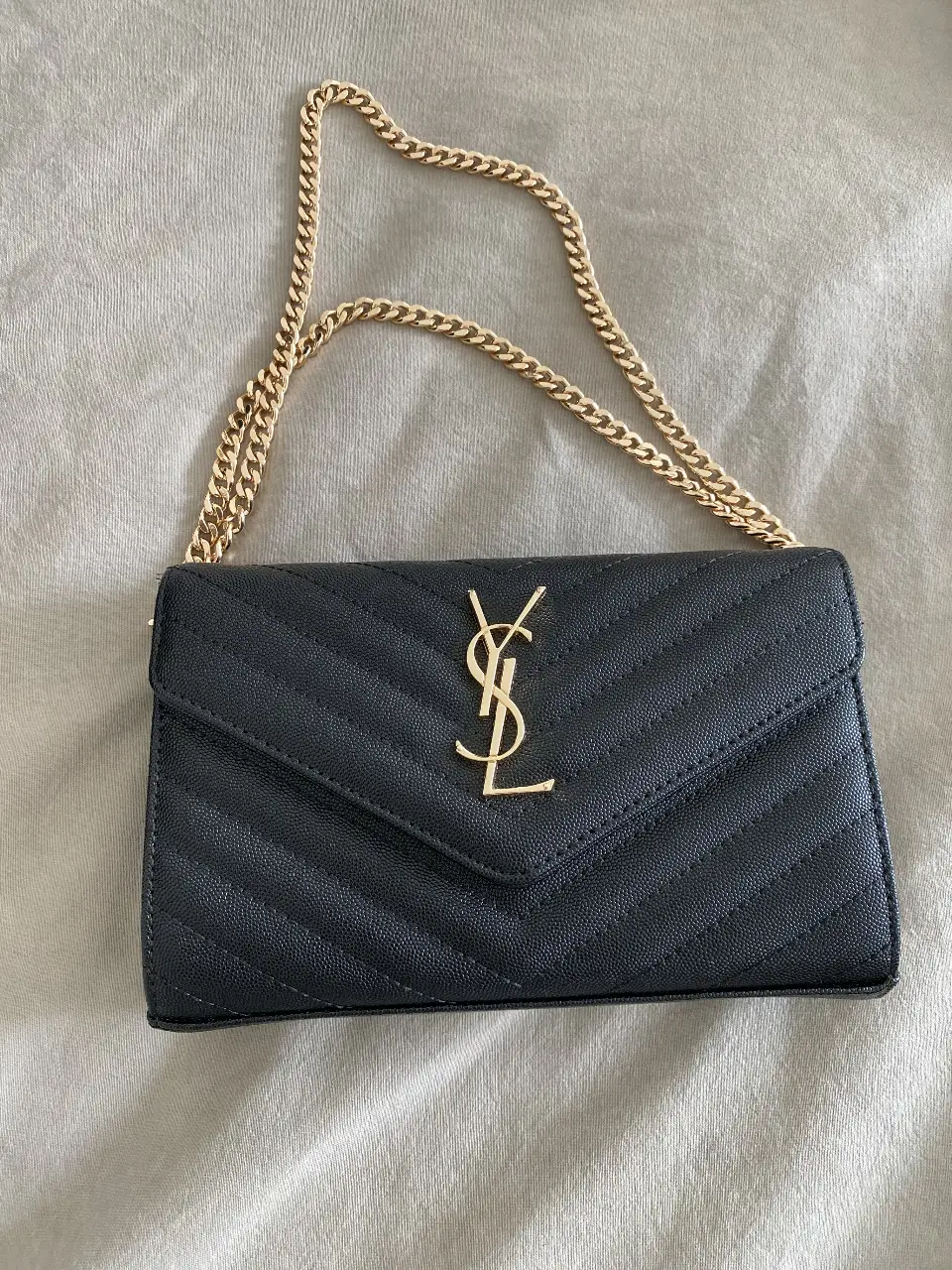 Cartera bandolera Saint Laurent en cuero negro con diseño acolchado en forma de chevron y cadena dorada. Un accesorio elegante y versátil para cualquier ocasión.