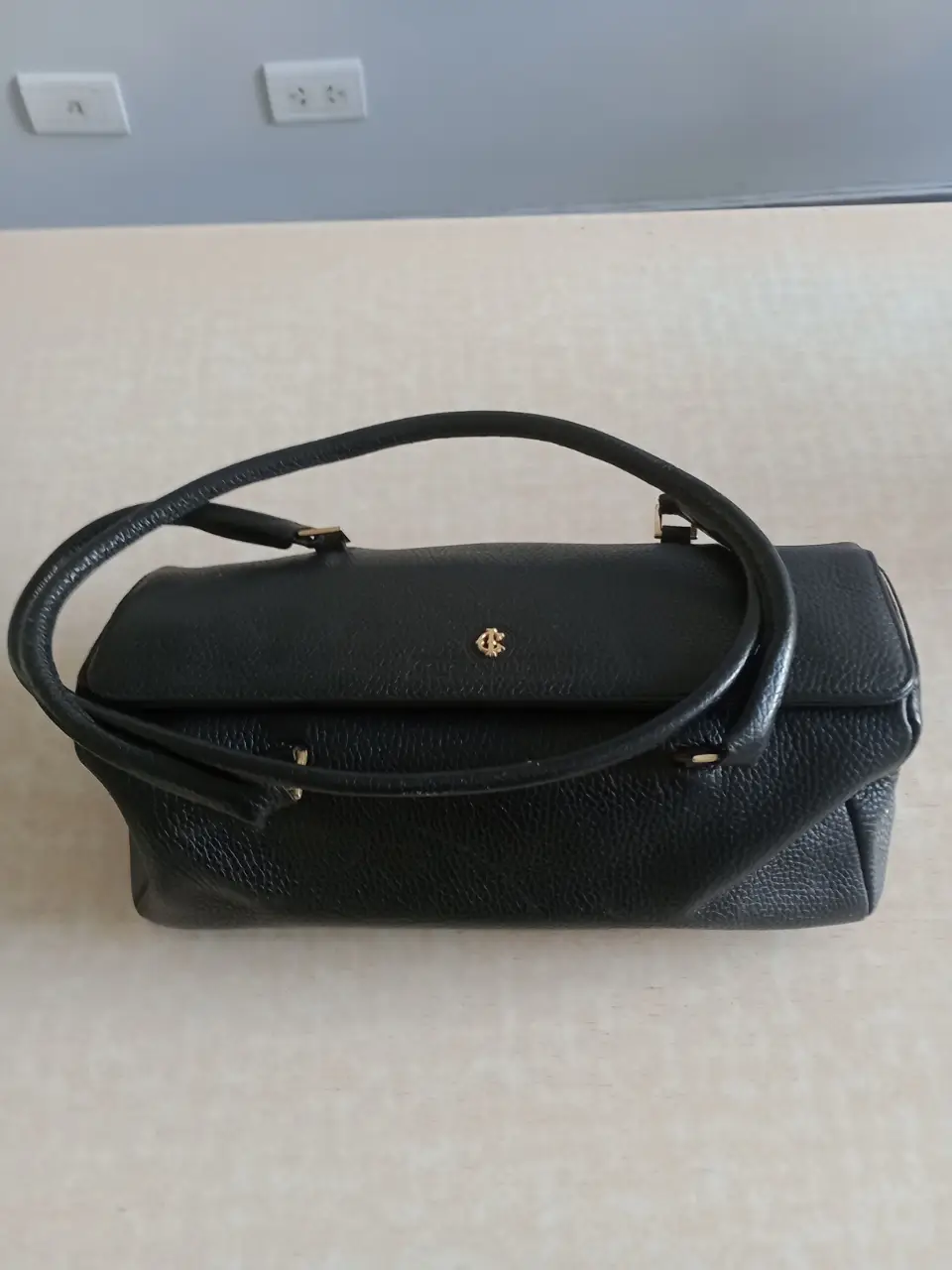 Cartera de mano vintage negra, con detalles dorados y asa superior. Ideal para eventos formales o para darle un toque elegante a tu look diario.