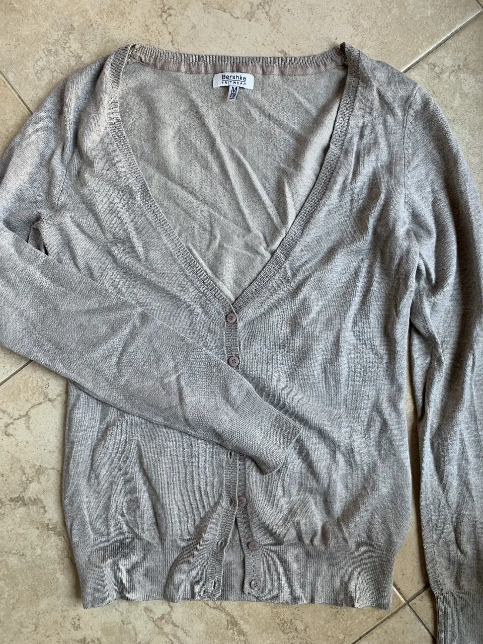 Cardigan de mujer Bershka, color gris claro, con botones y cuello en V. Ideal para un look casual y cómodo.