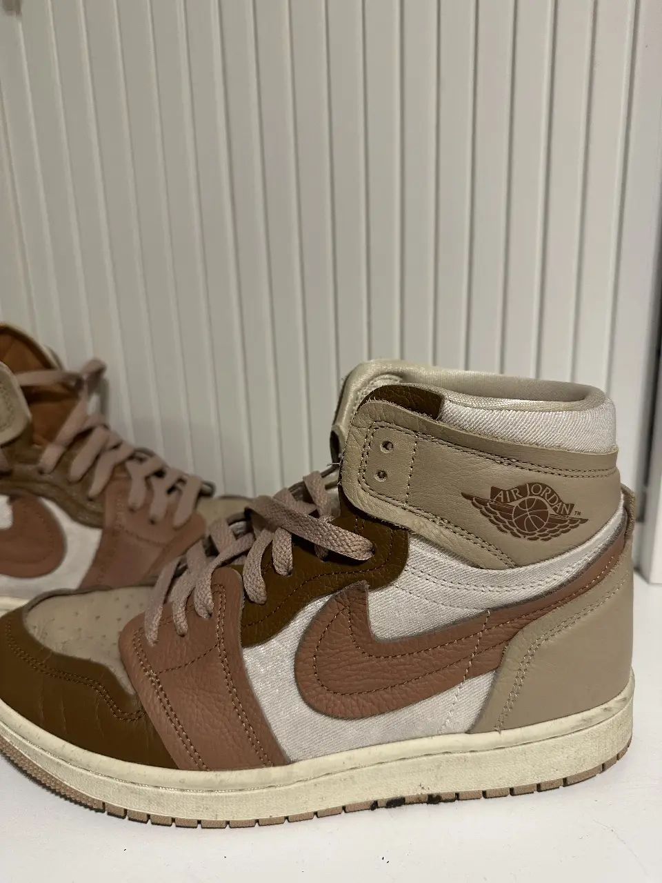 Zapatillas Air Jordan 1 High "Palomino". Diseño icónico con detalles en marrón y blanco, ideales para un look urbano y moderno. Perfectas para combinar con cualquier outfit casual.