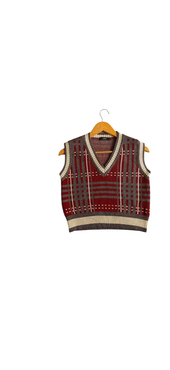 Chaleco de lana con diseño a cuadros en tonos bordeaux, gris y crudo. Cuello en V y detalles a contratono. Usalo con camisas para un lookazo. Vintage impecable. 