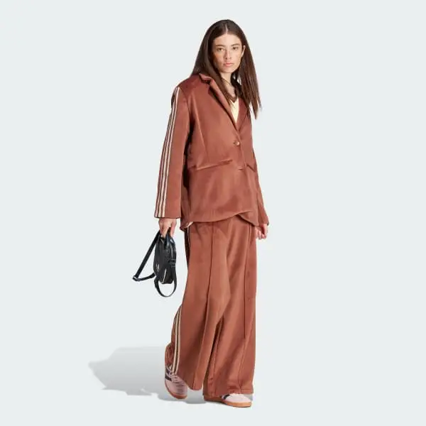 Conjunto Adidas de Blazer y Pantalón ancho color camel. El Blazer tiene las tres tiras de la marca y el logo. El pantalón tiene bolsillos con cierre. Confeccionado en Velvet, mano Corderoy. Super calentito y Mega canchero. Pieza de sastrería íntegramente forrada. Talle S amplio. Tiene un solo uso. 
