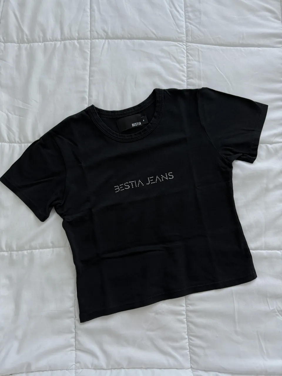 Remera negra de algodón con brillos. Tiene un corte moderno y es perfecta para un look canchero.