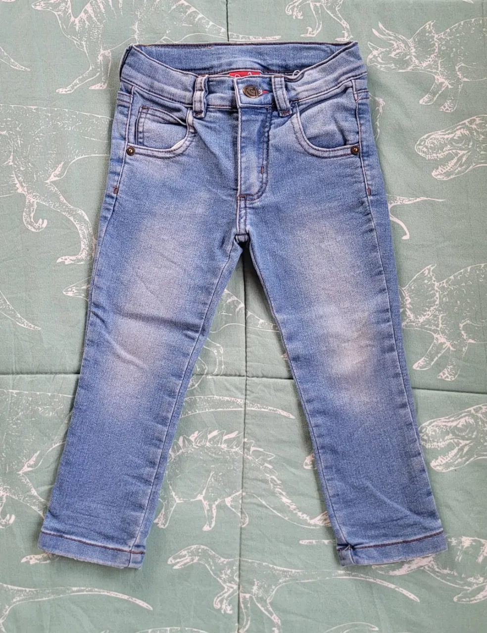 Jean de algodón para niños, color azul claro, con bolsillos delanteros y traseros. Cierre y botón en la cintura.