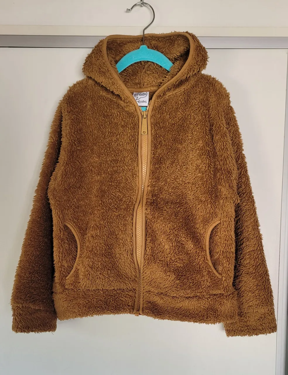 Buzo de micropolar con capucha y cierre completo. Posee bolsillos laterales.