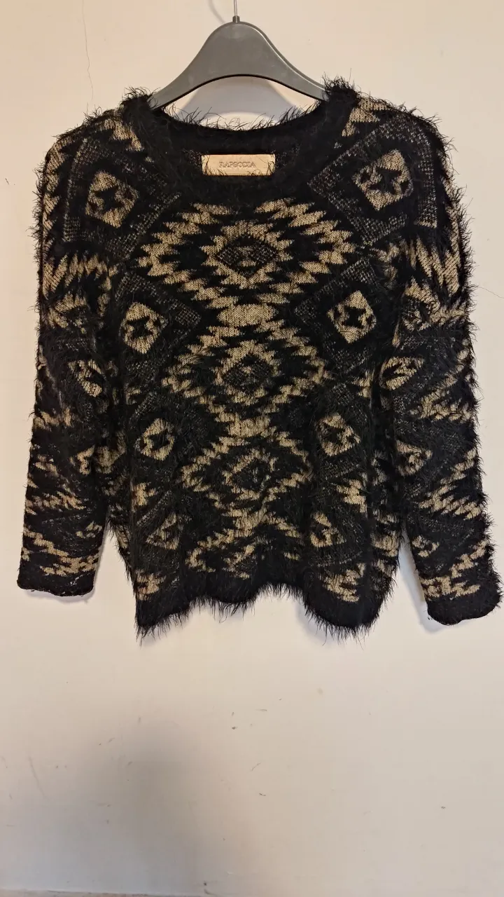 Sweater de tejido suave con estampa geométrica en tonos tierra y negro. Posee detalles de pelo que le dan un toque único y moderno. Ideal para un look canchero y abrigado. va hasta talle 2