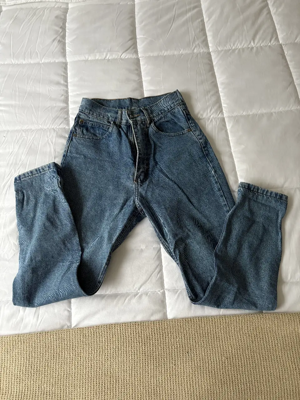 Jeans rectos de denim azul, tiro alto, ideales para un look casual y versátil. Un clásico que no puede faltar en tu guardarropa.