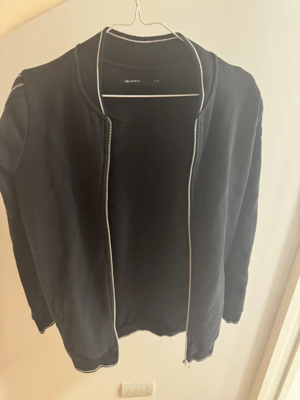 Buzo negro con cierre, ideal para un look casual y cómodo.  ofrece un ajuste perfecto y un estilo versátil para cualquier ocasión.
