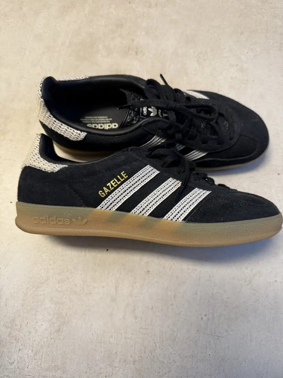 Zapatillas Adidas Gazelle negras con detalles en blanco tipo tejido y suela de goma. Un clásico del calzado deportivo. 2 posturas, me equivoqué en el talle me quedan ajustadas. impecables. Talle 7 US