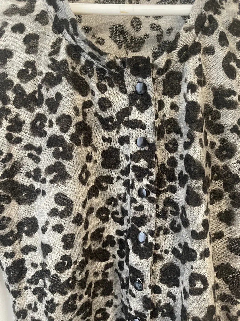 Cardigan de mujer con estampado de leopardo en tonos grises y negros. Ideal para un look casual y canchero. Perfecto para combinar con jeans o pantalones de vestir.