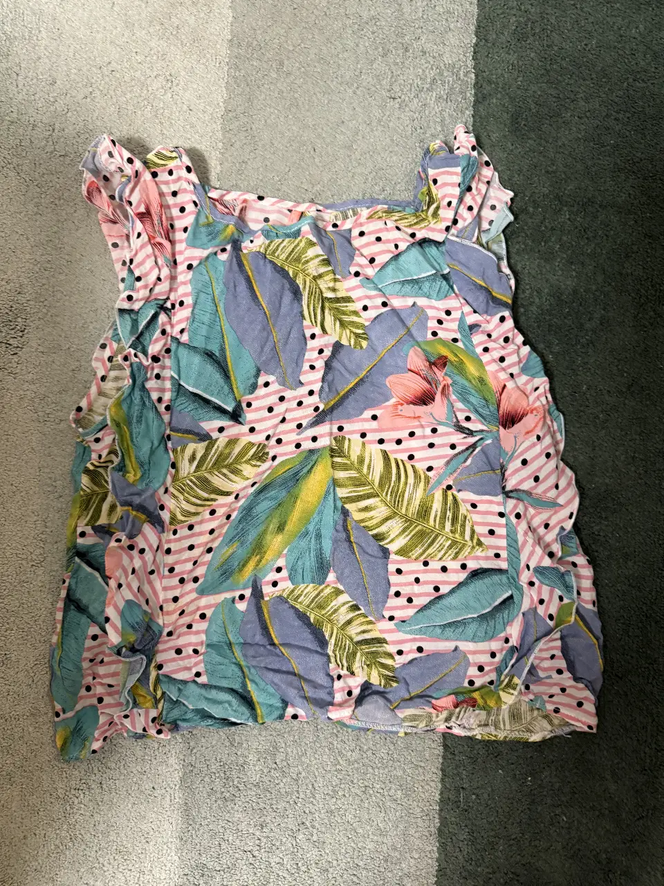 Top de mujer con estampado floral y rayas rosas. Diseño con volados y hojas en tonos azules y verdes. Ideal para un look fresco y primaveral.