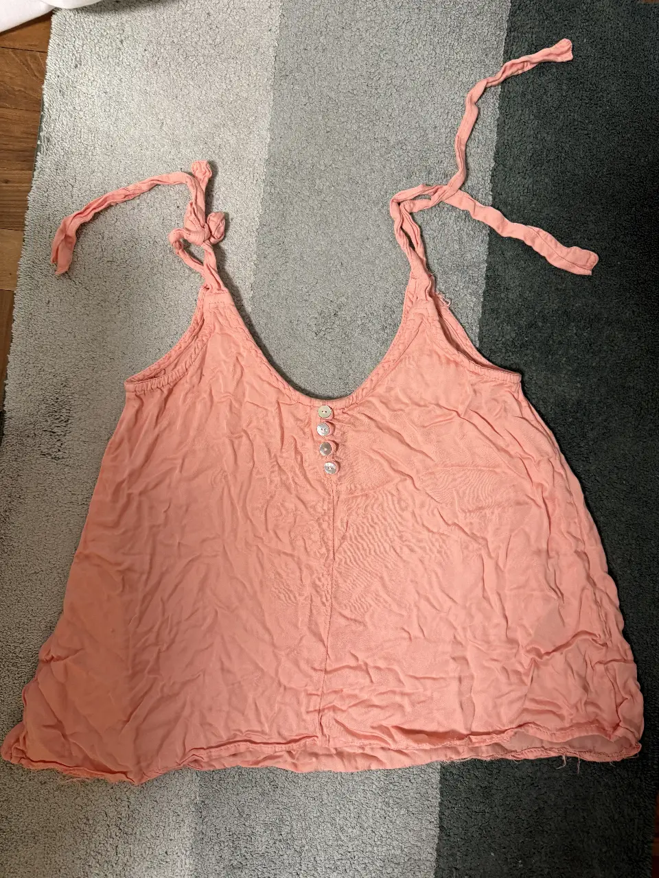 Top de mujer color rosa con tirantes ajustables y botones decorativos. Ideal para un look casual y fresco.