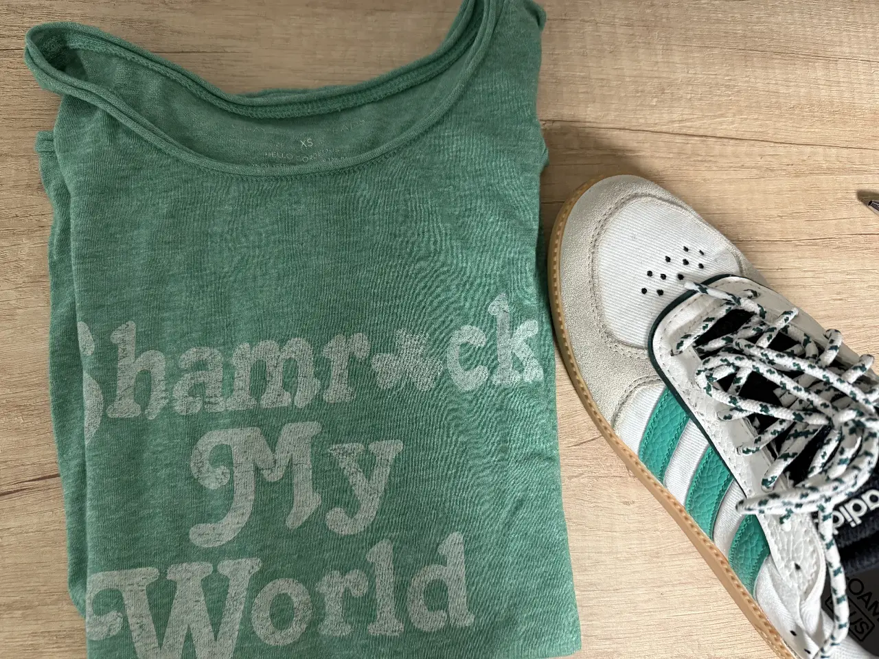 Remera urbana verde con estampado "Shamrock My World". Talle XS, ideal para un look casual y cómodo.