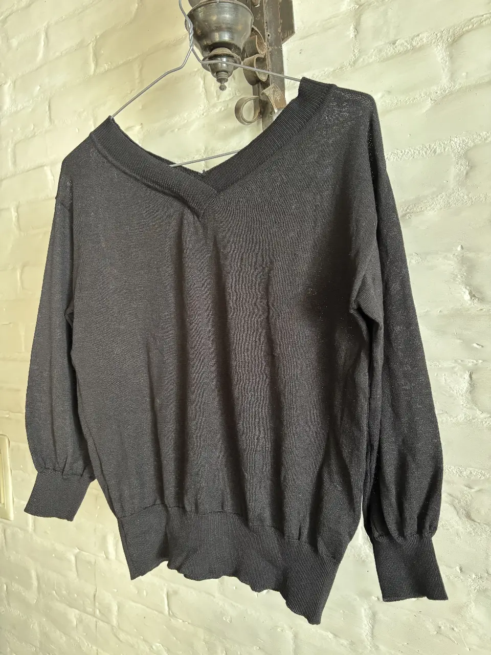 Sweater negro con cuello en V, manga larga y puños ajustados. Ideal para un look casual y versátil. medidas: espalda 43 sisa 48. largo 58 cm