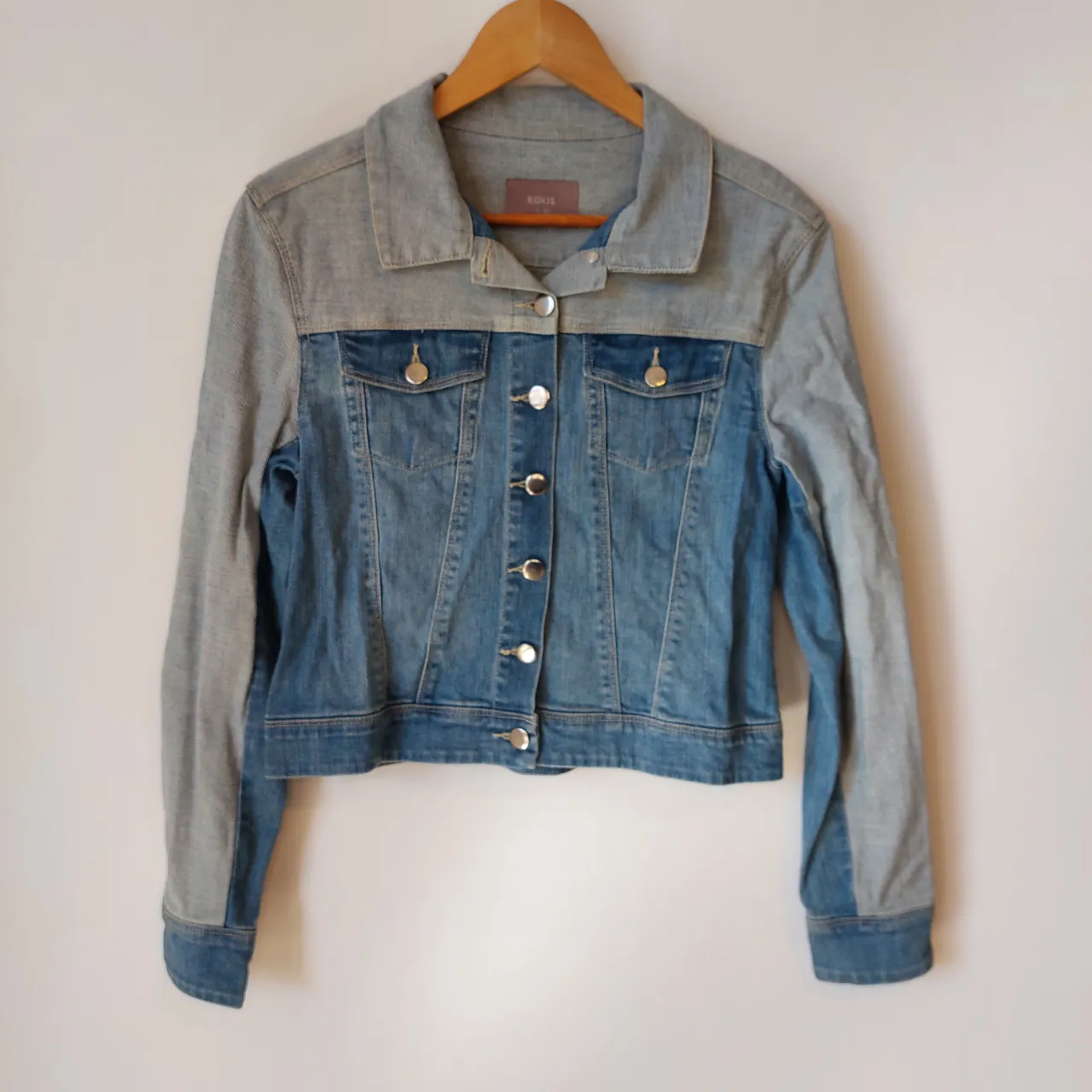 Campera de jean bicolor Tiene cuello, botones al frente y bolsillos con tapa.