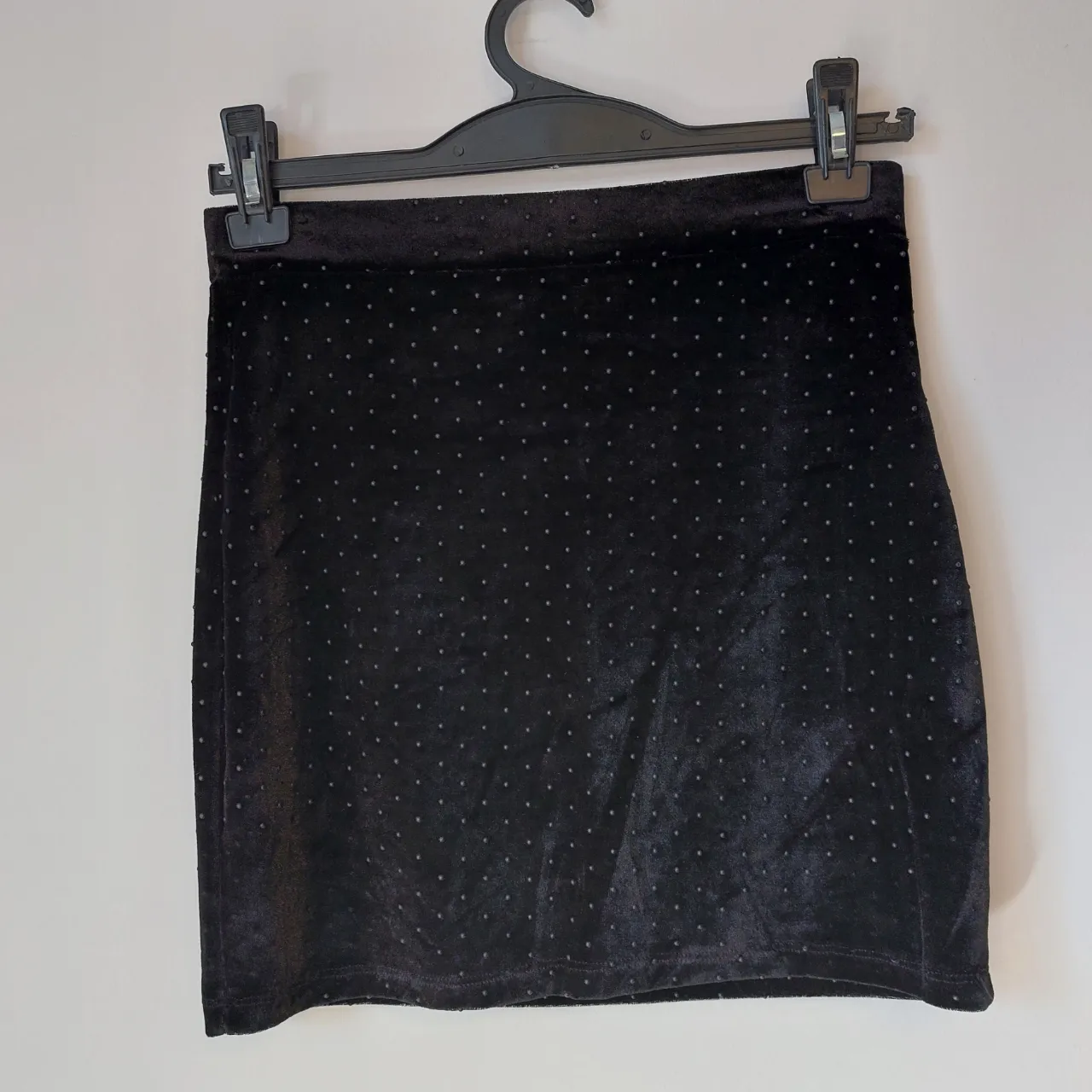 Pollera negra corta con pequeños puntos negros estampados. Tela de terciopelo.