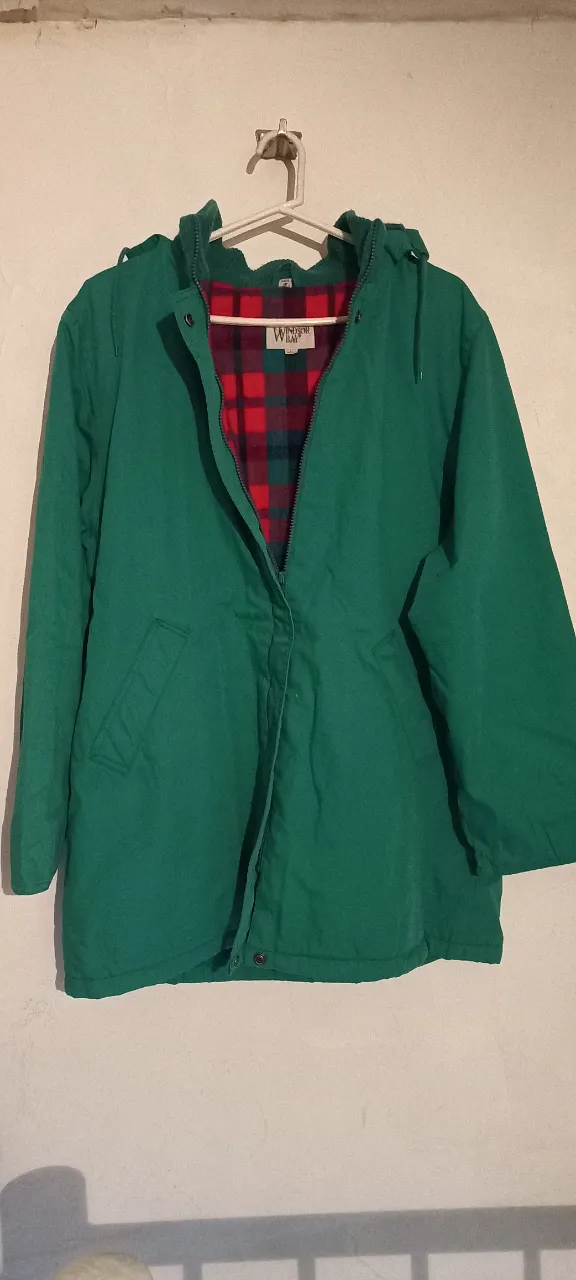 Campera verde con capucha y forro a cuadros. Ideal para el invierno, con cierre y bolsillos.