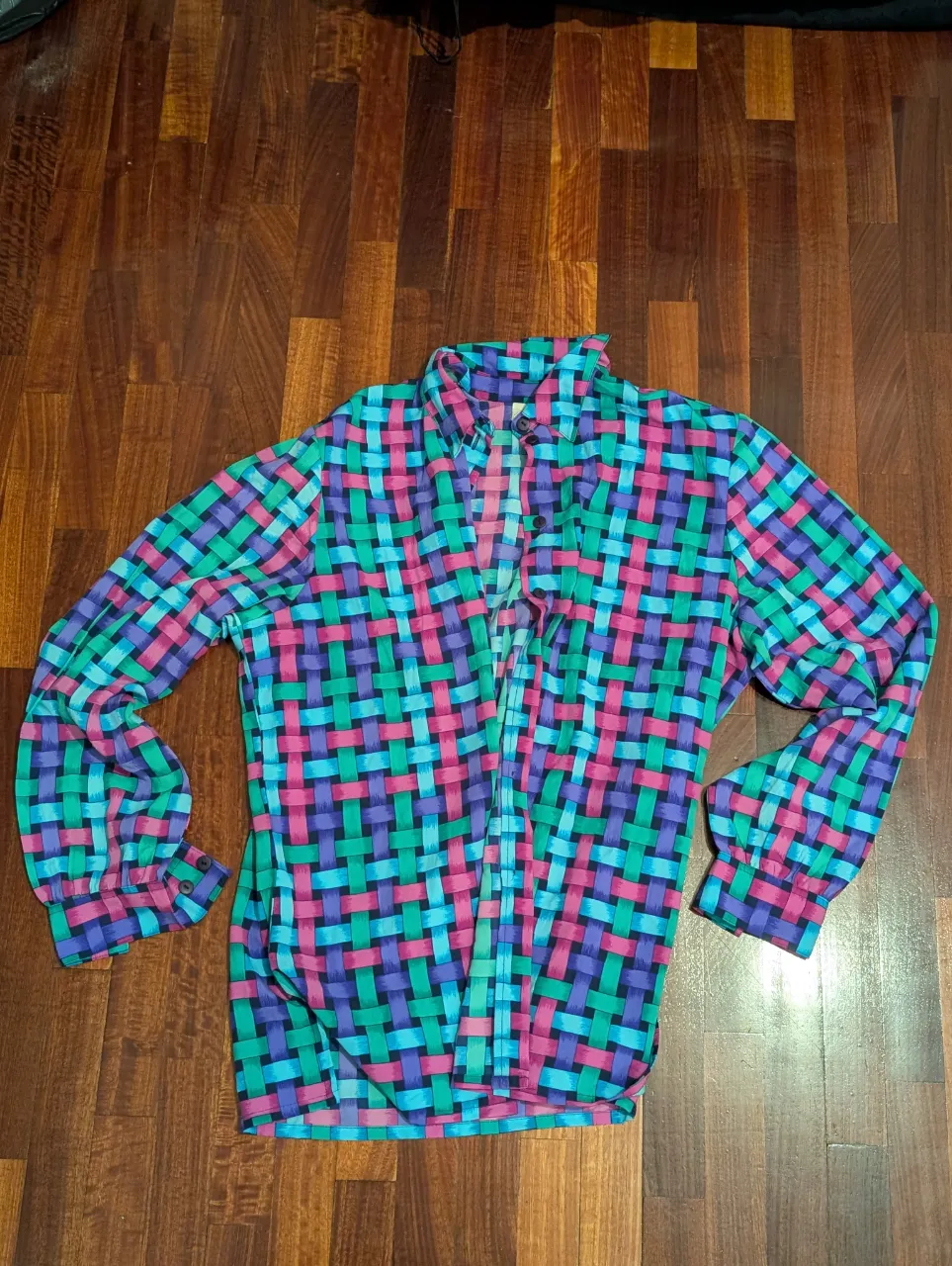 Camisa estampada con diseño de cuadros en tonos vibrantes. Ideal para un look retro y llamativo. Perfecta para combinar con jeans o pantalones de vestir.