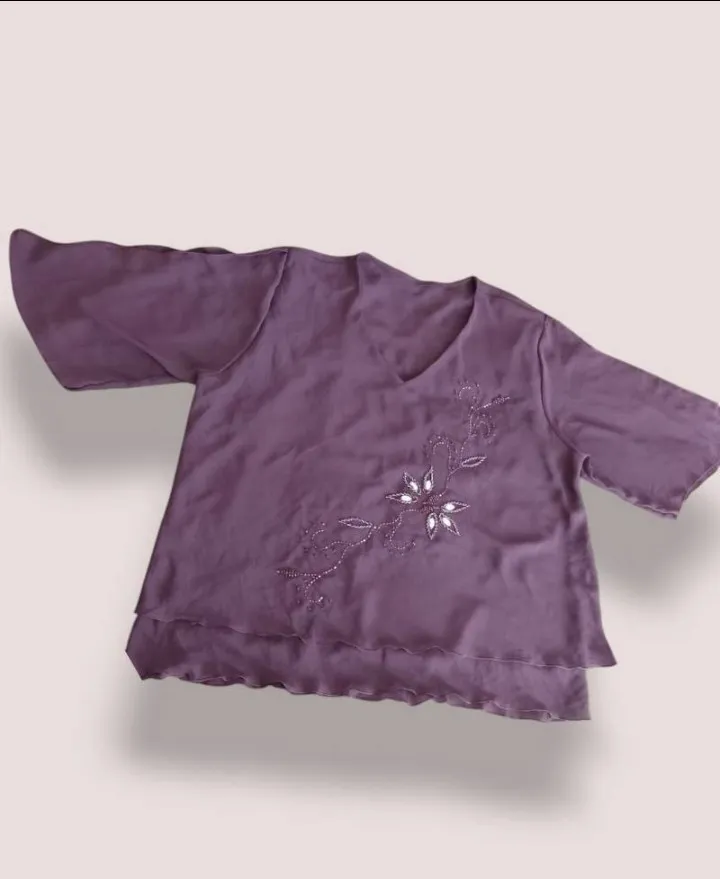 Blusa de mujer en color violeta con detalle floral bordado. Diseño con mangas amplias y escote en V. Talle xxl sin uso impecable medidas contorno de busto: 148 cm sisa: 32 cm largo primera capa: 67 cm largo segunda capa: 77 cm