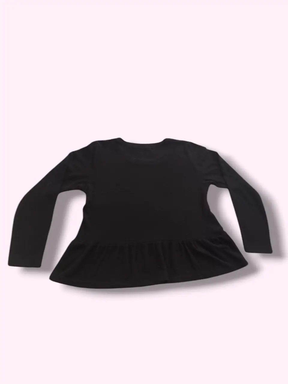 Remera de manga larga negra con detalle de volado en la cintura. Ideal para un look casual y cómodo. Medidas Contorno de busto: 95 cm Largo: 55 cm Largo de manga: 54 cm  Sisa: 22 cm