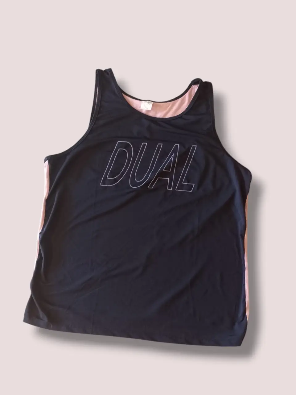 Musculosa deportiva negra con detalle en rosa y la palabra "DUAL" estampada. Ideal para entrenamientos. Medidas Contorno de busto: 120 cm  Largo: 70 cm