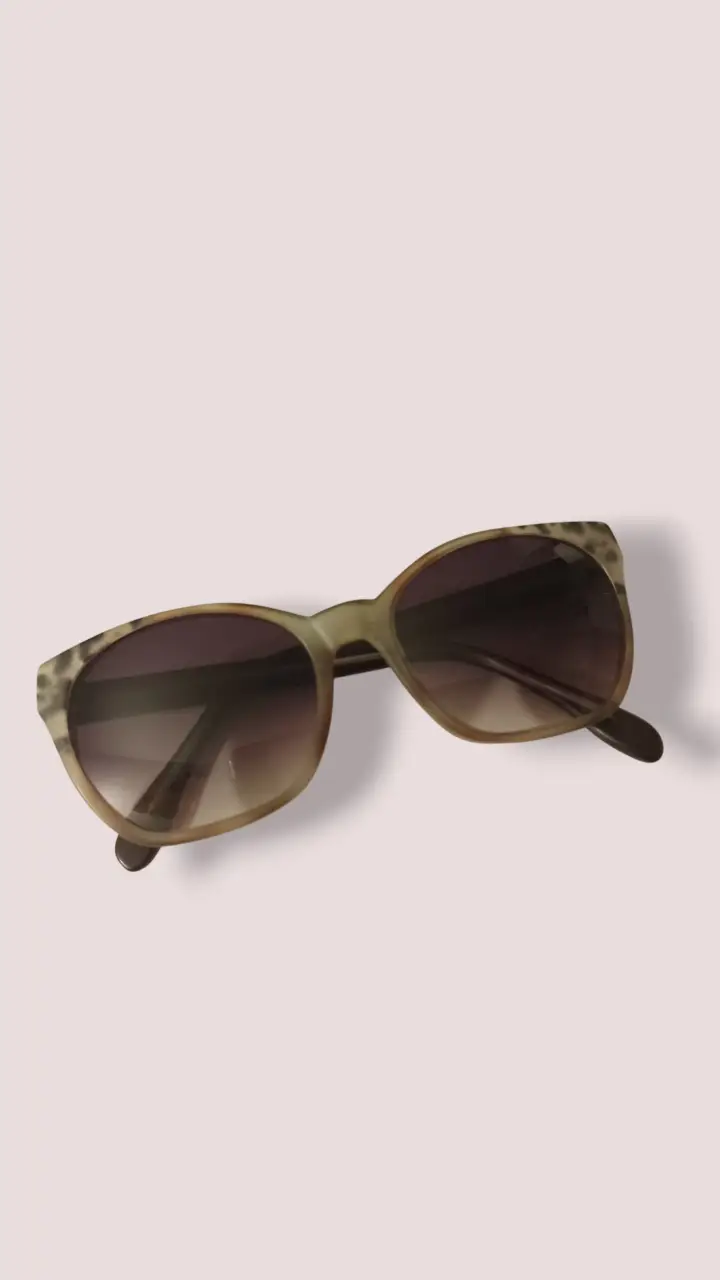 Anteojos de sol con marco marrón y detalles de estampado animal print en las patillas. Lentes degradadas. Marca uptown comprado en óptica Roma Vision