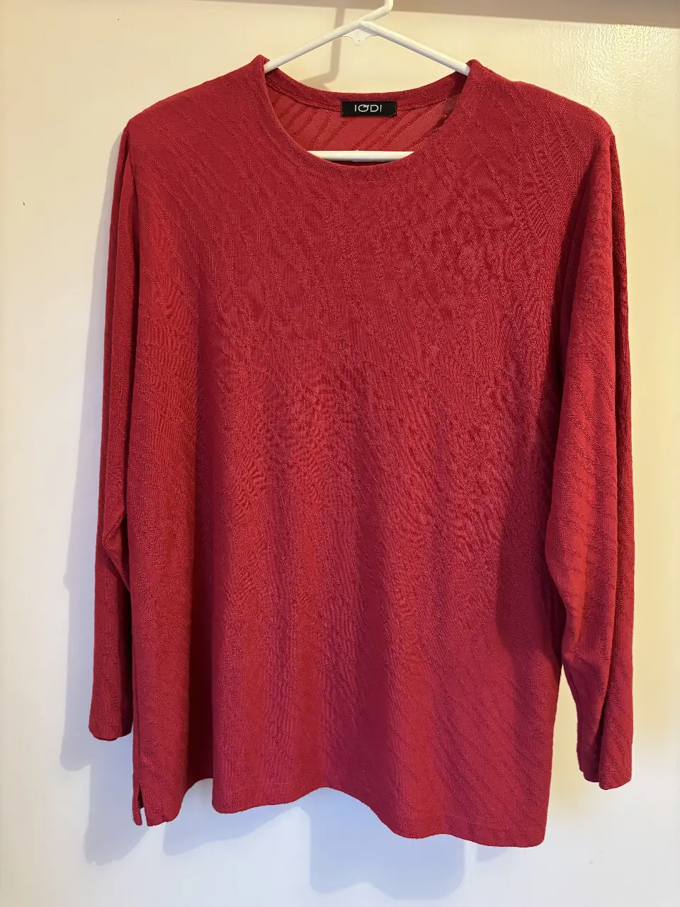 Sweater largo de color rojo, con cuello redondo y mangas largas. Ideal para un look casual y cómodo.