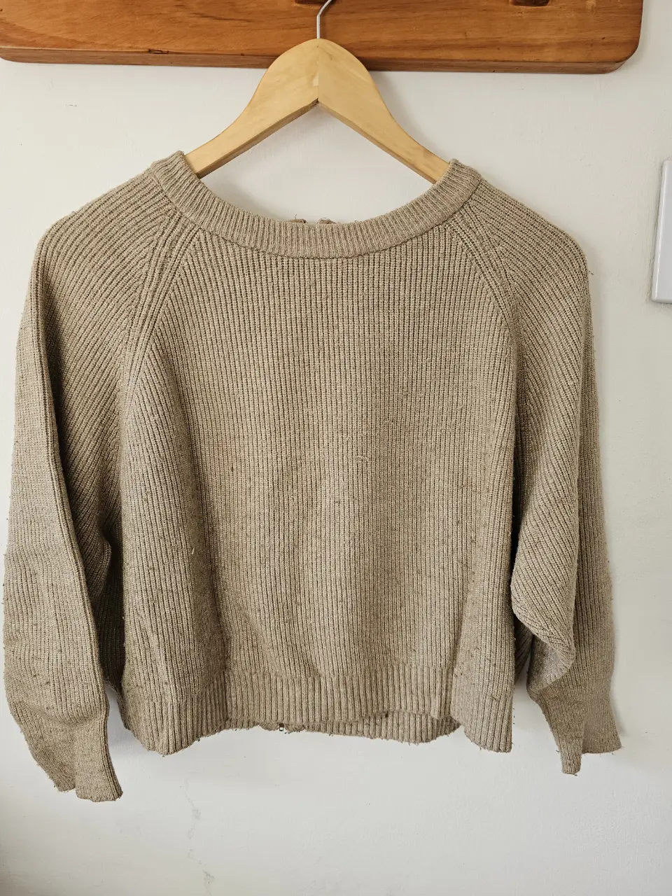 Sweater de tejido grueso color beige, con cierre en la espalda. Ideal para un look casual y abrigado.