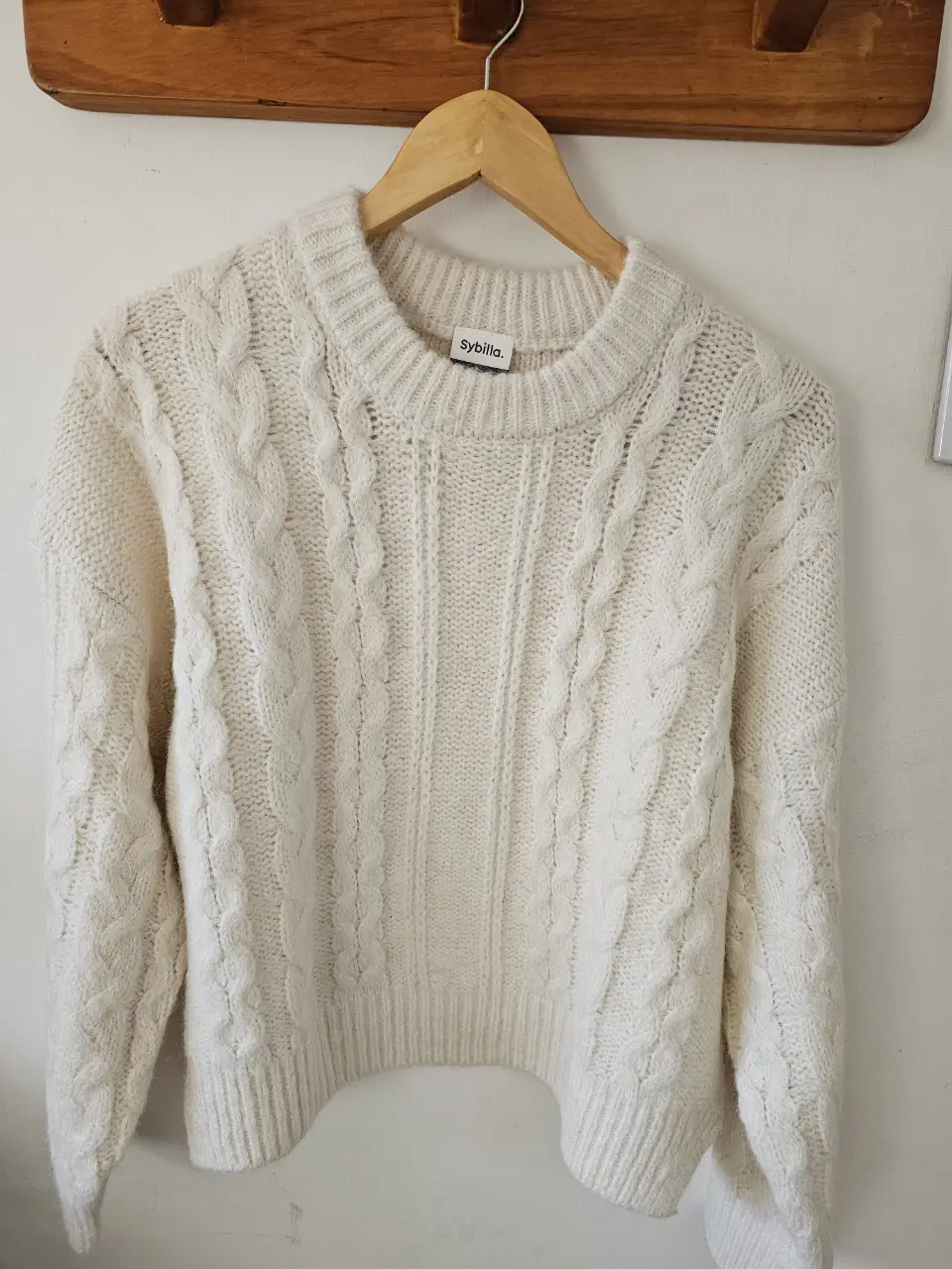 Sweater color blanco con diseño de trenzas. Cuello redondo y mangas largas. Ideal para un look casual y abrigado.