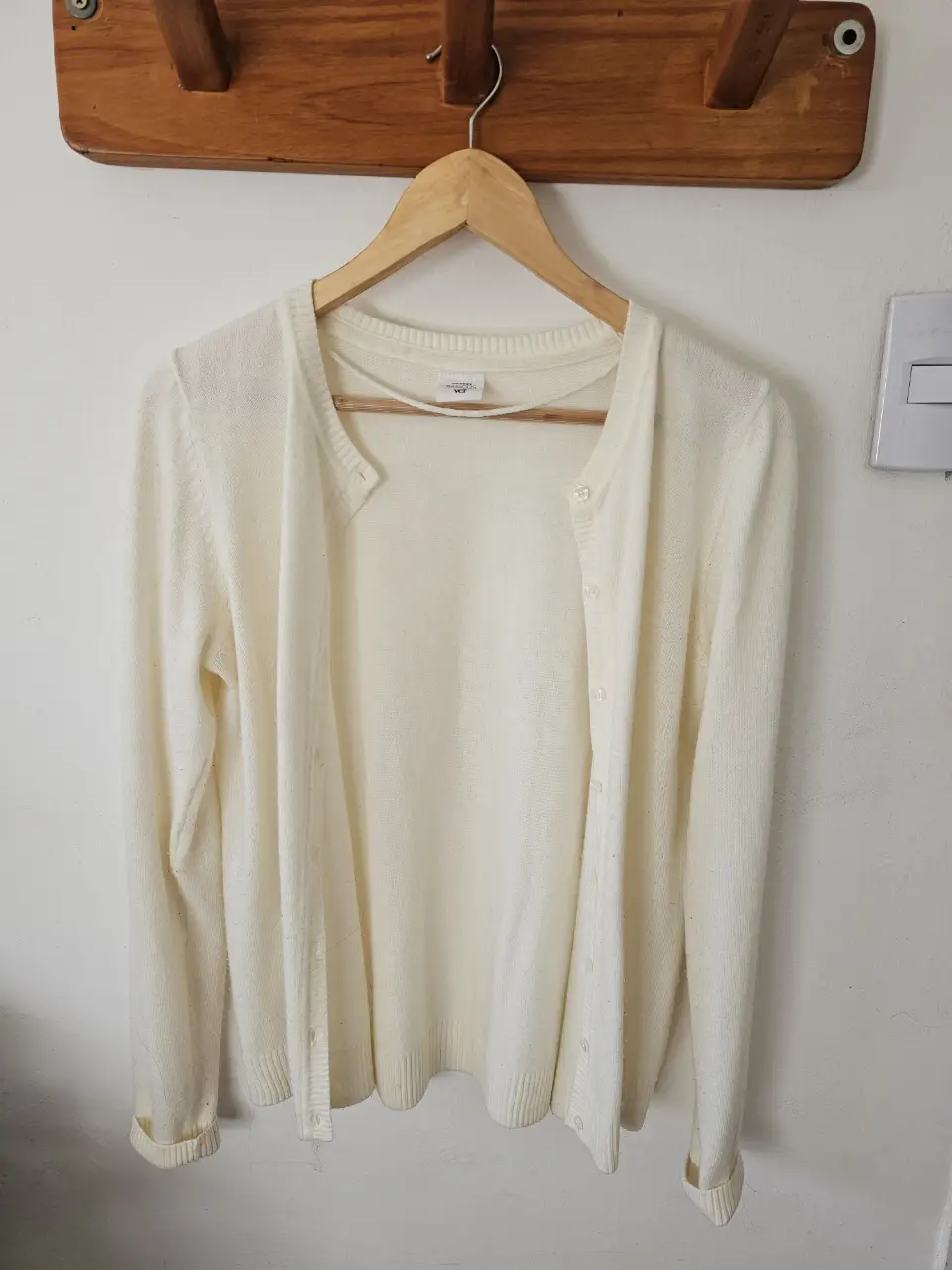 Cardigan de punto color crudo, con botones. Ideal para usar en cualquier ocasión.