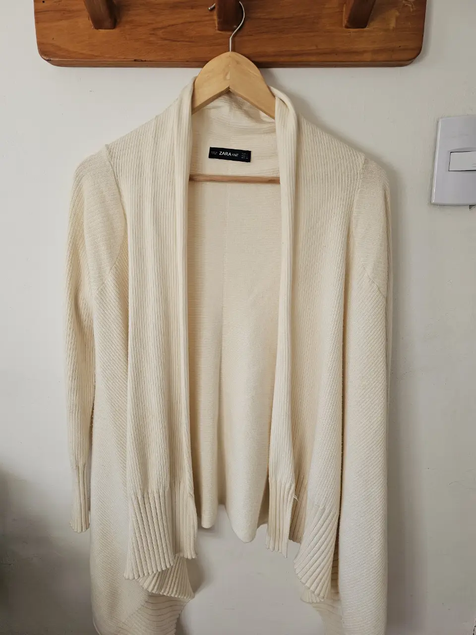 Cardigan de mujer color crudo, de la marca Zara. Ideal para usar en otoño o invierno. Es de tejido suave y cómodo, con un diseño elegante y versátil.