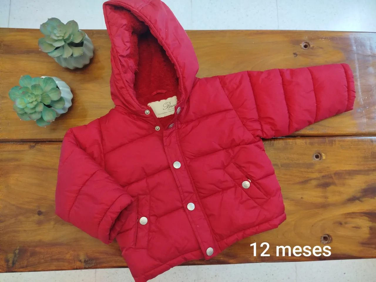 Campera roja acolchada para bebé, con capucha y cierre. Ideal para el invierno, abrigada y cómoda.
