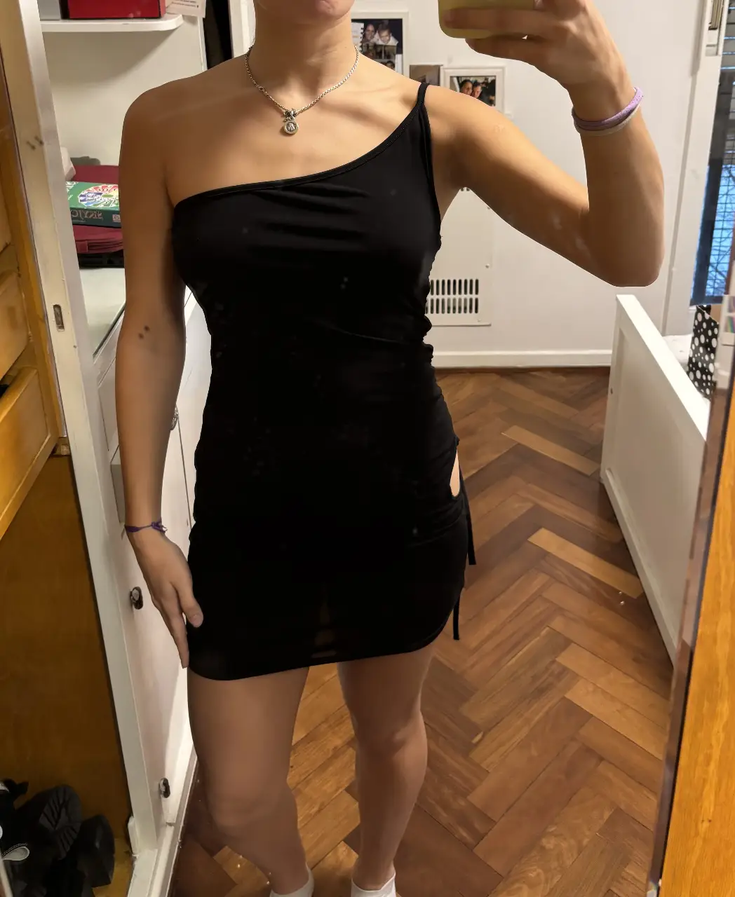 Vestido mini negro de un solo hombro con detalle cut out en la cintura. Ideal para una salida nocturna o evento especial.