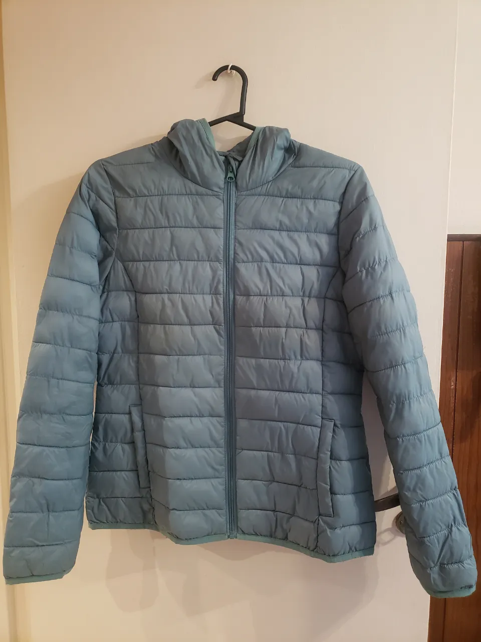 Campera acolchada con capucha, ideal para el frío. Posee cierre al frente y bolsillos laterales. Su diseño moderno y acolchado la hace perfecta para el día a día.