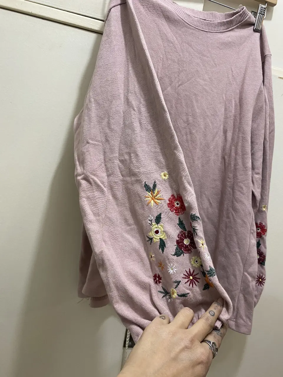 Sweater rosa con mangas bordadas con flores. Ideal para un look casual y femenino.