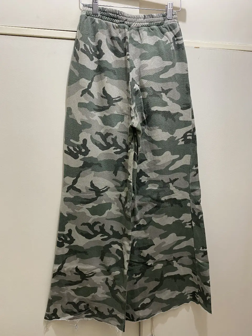 Pantalón suelto de camuflaje en tonos grises y verdes. Ideal para un look casual y cómodo. Perfecto para combinar con zapatillas o botas.