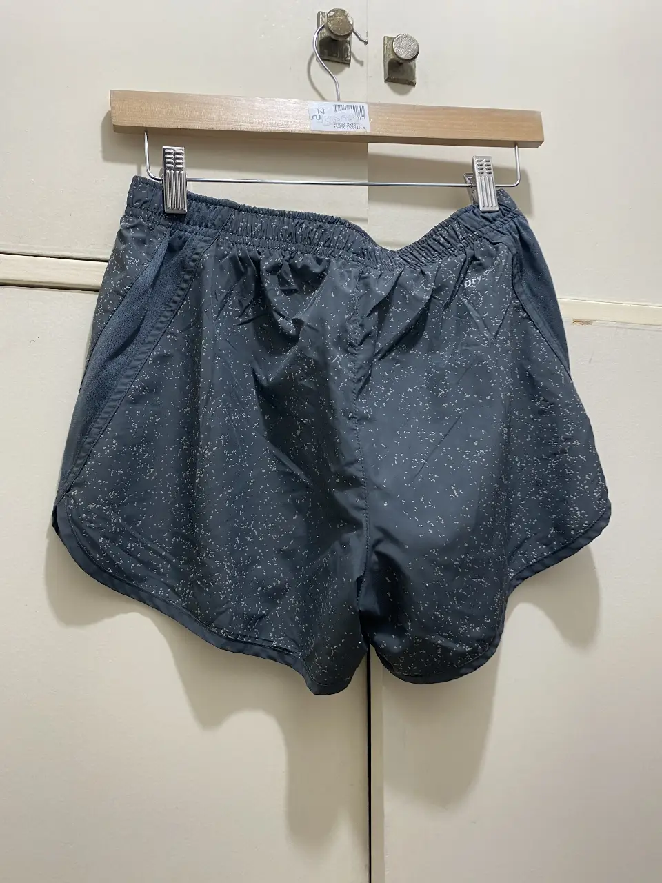 Short deportivo gris con detalles blancos. Ideal para running y entrenamientos.