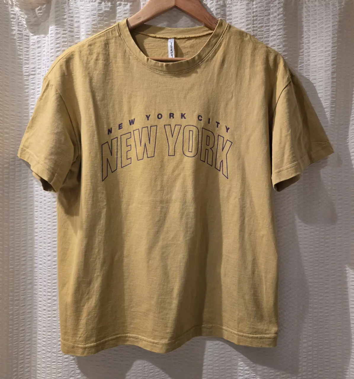 Remera color mostaza manga corta con estampado "New York City" en color azul marino. Talle XS pero puede ser S/M