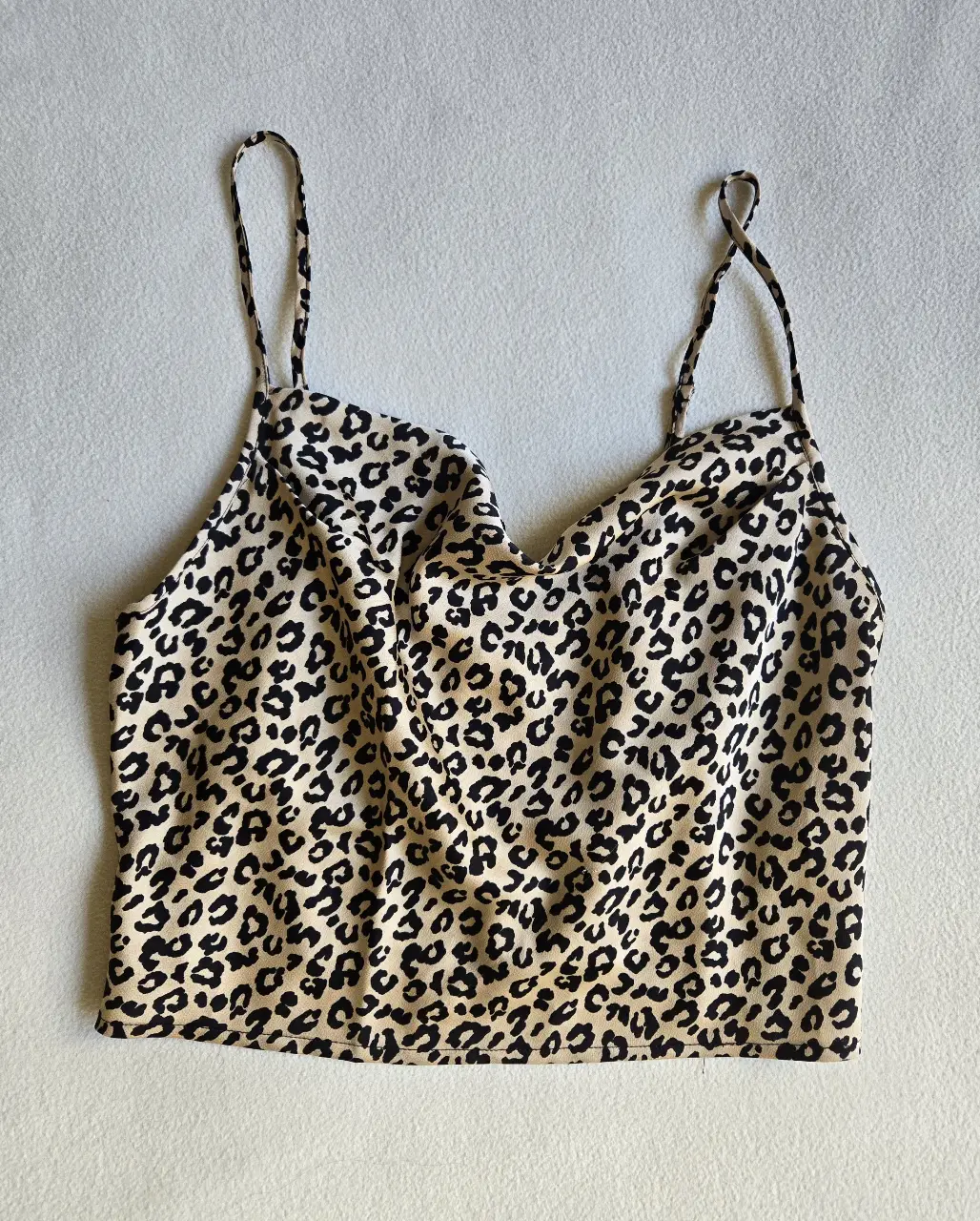 Top de mujer con estampado de leopardo. Diseño con tirantes finos y escote en forma de pico. Ideal para un look casual y moderno.