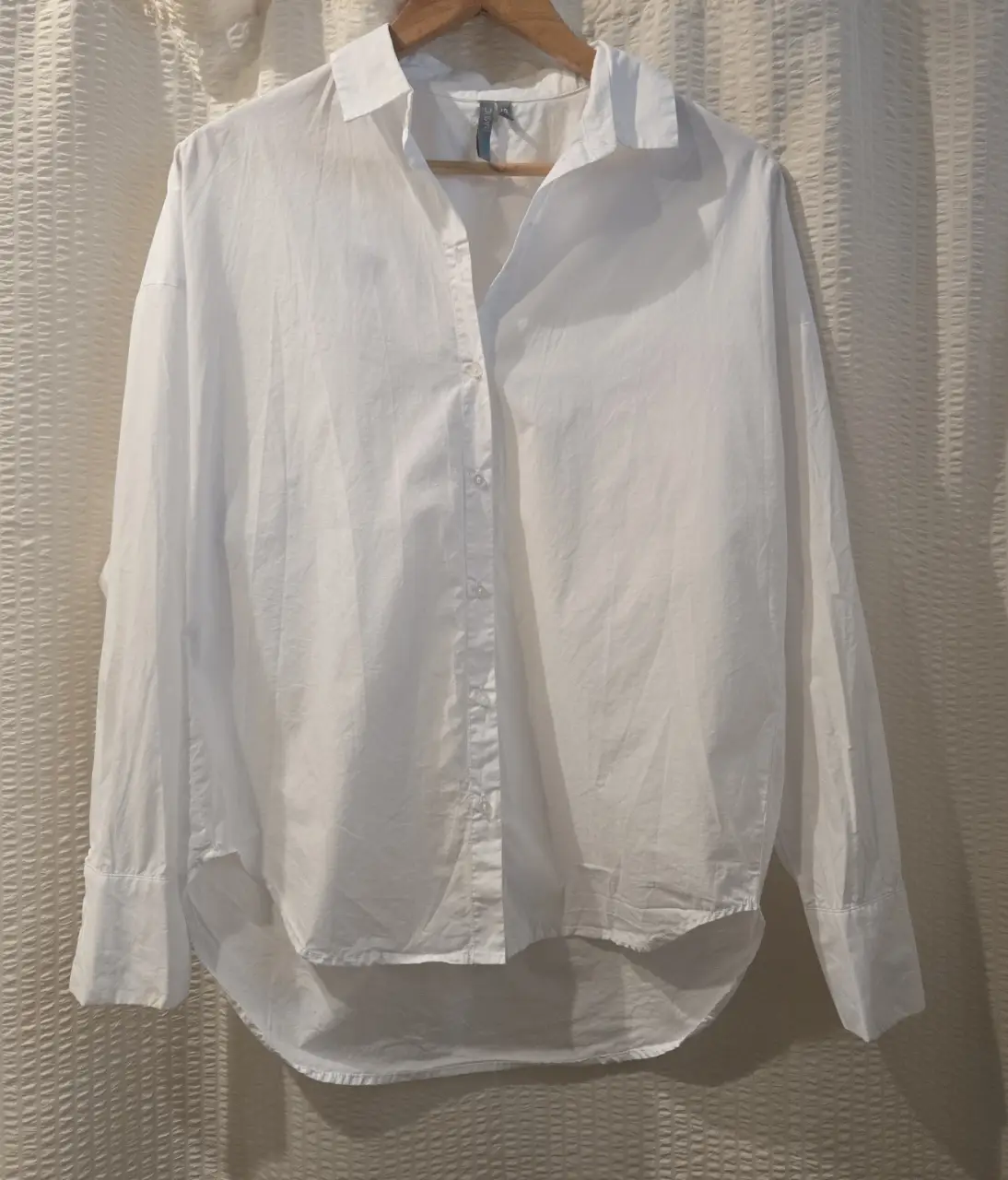 Camisa blanca de poplin, de corte holgado y mangas largas. Ideal para un look casual y cómodo.