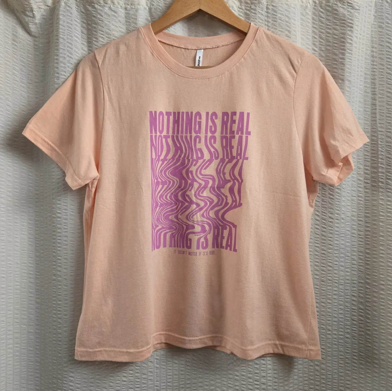 Remera de manga corta color durazno con estampado en color rosa