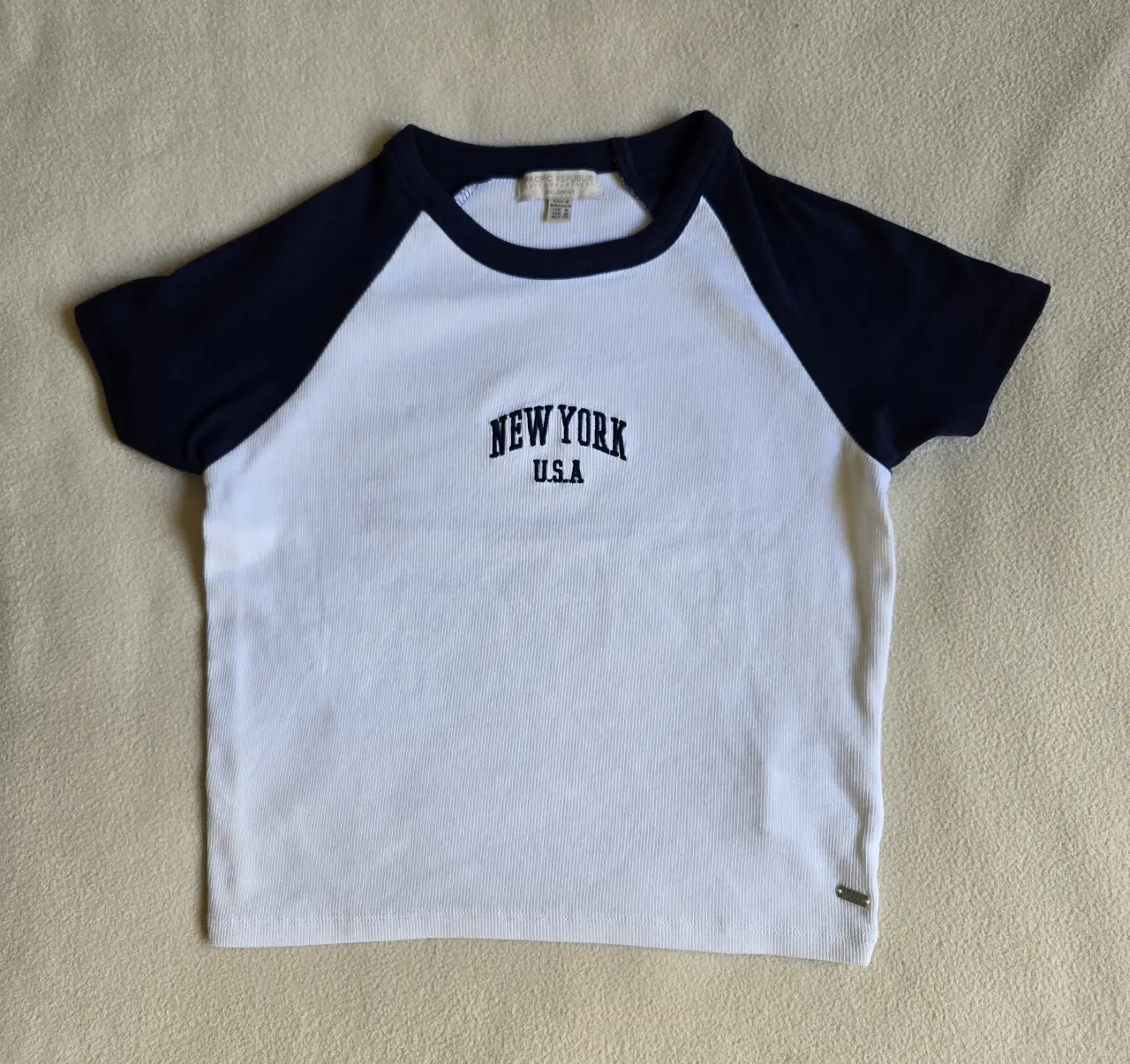 Remera de morley manga corta para mujer, con mangas en color azul marino y cuerpo blanco. Estampado "NEW YORK U.S.A" en el frente. Marca Pull and bear (Pacific republic). Talle M pero va para un S tambien