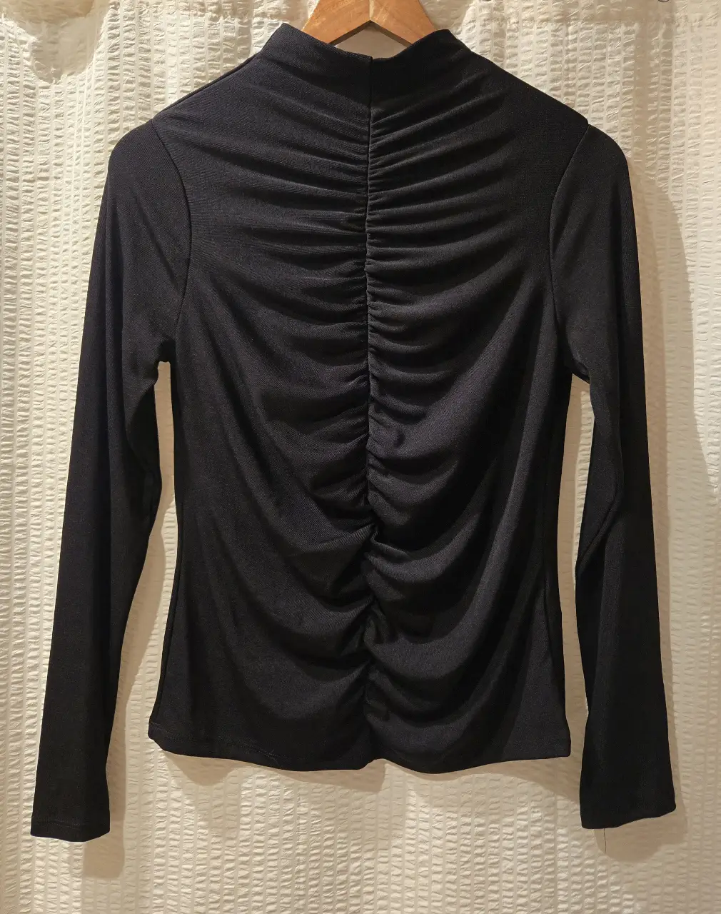 Remera manga larga negra. Con cuello alto y fruncido en el frente. 93% poliester 7% elastano