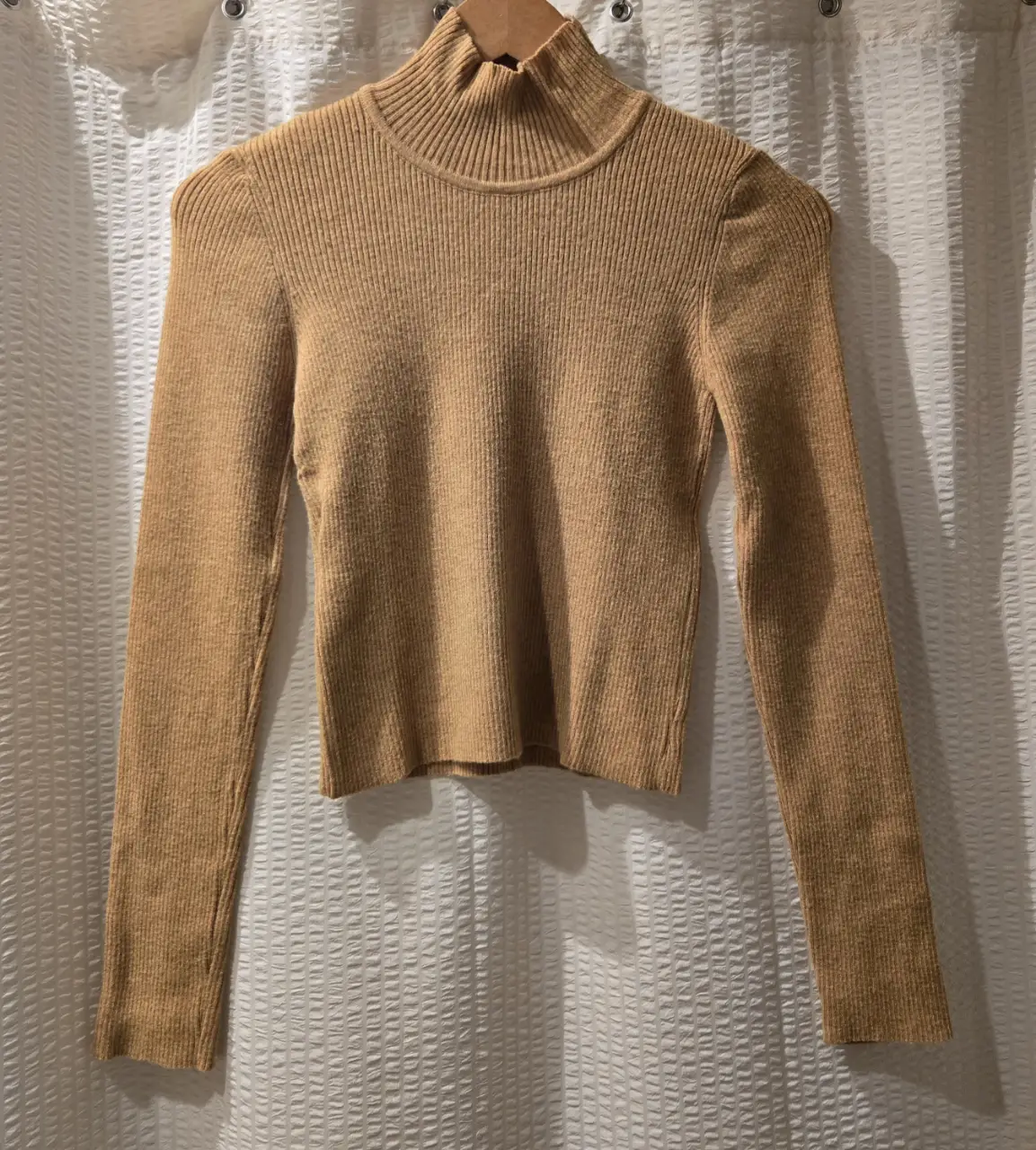 Sweater color mostaza/marrón con cuello alto y mangas largas. Ideal para un look casual y abrigado. 47% rayon 25% nylon 28% pbt