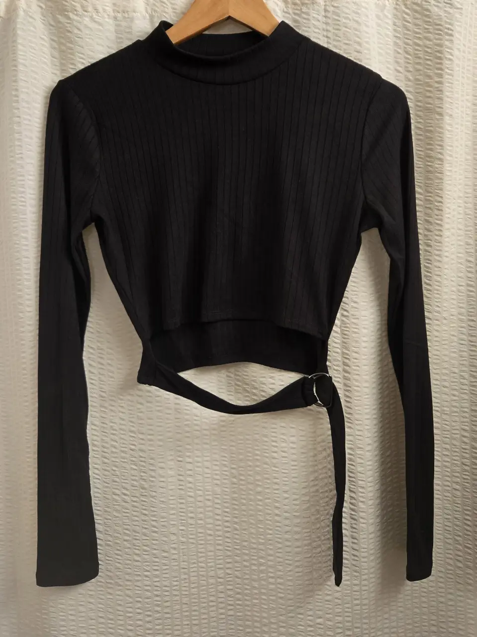 Top negro de manga larga con cuello alto y detalle de tira con hebilla. Morley ancho. 95% poliester 5% spandex