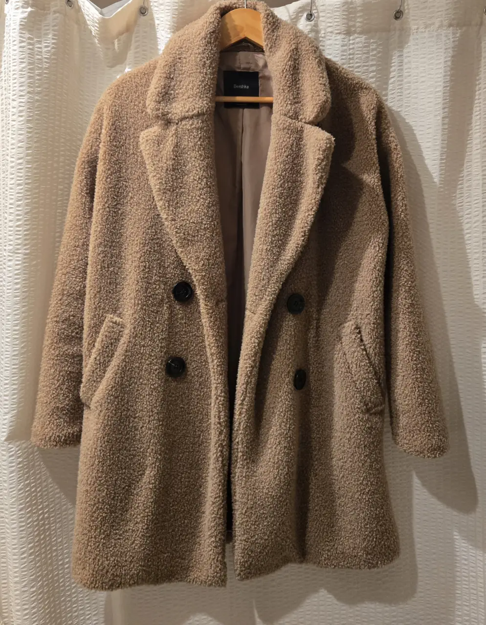 Tapado de corderito Bershka color camel, con solapas, dos bolsillos delanteros y botones. Talle XS/S. Largo a la rodilla. Tela exterior 73% acrilico 27% poliester. Forreria 100% poliester